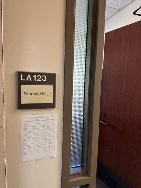 An office door nameplate reading LA123, Tanmay Hinge