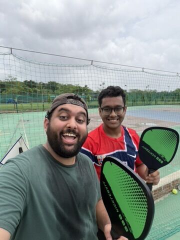 Tanmay and a friend with paddles on a pickleball court in Mumbai