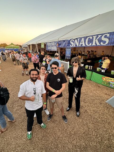 Tanmay with friends at an outdoor festival at dusk